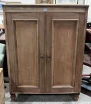 A Victorian cupboard enclosed by a pair of panel doors on turned feet. 42" w x 56½" h.