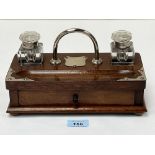 A mahogany inkstand with two glass wells and plated mounts. 10" wide.