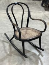 A bentwood rocking chair with caned seat.