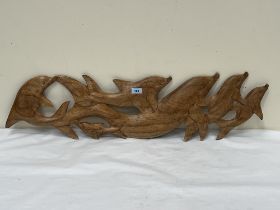 A pod of dolphins carved wood plaque. 39" wide.