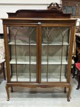 A 1920s mahogany display cabinet enclosed by a pair of astragal glazed doors. 48" wide.