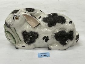 A 19th Century Staffordshire rabbit. 9½" long. Large loss to ear.