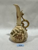 A Royal Worcester blush ivory ewer, gilded and painted with foliage. 8½" high.