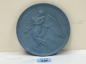 A 19th Century blue plaque decorated with an angel in relief. 6" diam.