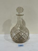 An early 20th Century cut glass decanter with musical box to base. 11" high.