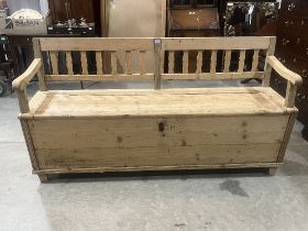 An East European pine box bench enclosed by a hinged lid. 72" wide.