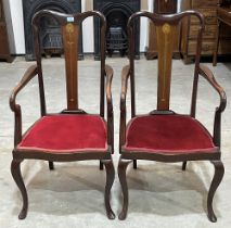 A pair of early 20th Century mahogany armchairs, the splats with inlaid Art-Nouveau stylised motif.