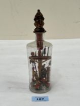 A 19th Century polychrome figure of the crucified Christ in a bottle. 7½" high.