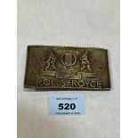 A bronze Rolls-Royce belt buckle.