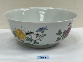 A Chinese famille-rose bowl, decorated with prunus, cricket and flying insects. Red seal mark. 10"