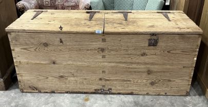 A pine chest enclosed by a pair of lids with iron strap hinges. 53" wide.