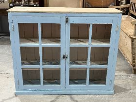 A painted pine cupboard enclosed by a pair of glazed doors. 48"w x 40½"h.