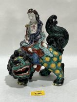 A Japanese polychrome and gilt porcelain Kannon and Shishi group. 20th Century. 8½" high.