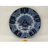 An 18th Century Delft dish decorated in blue and white with foliage. 9" diam.