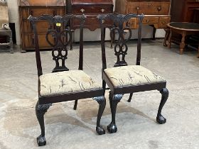 A pair of 18th Century Irish mahogany dining chairs with shaped tracery splats, on carved cabriole