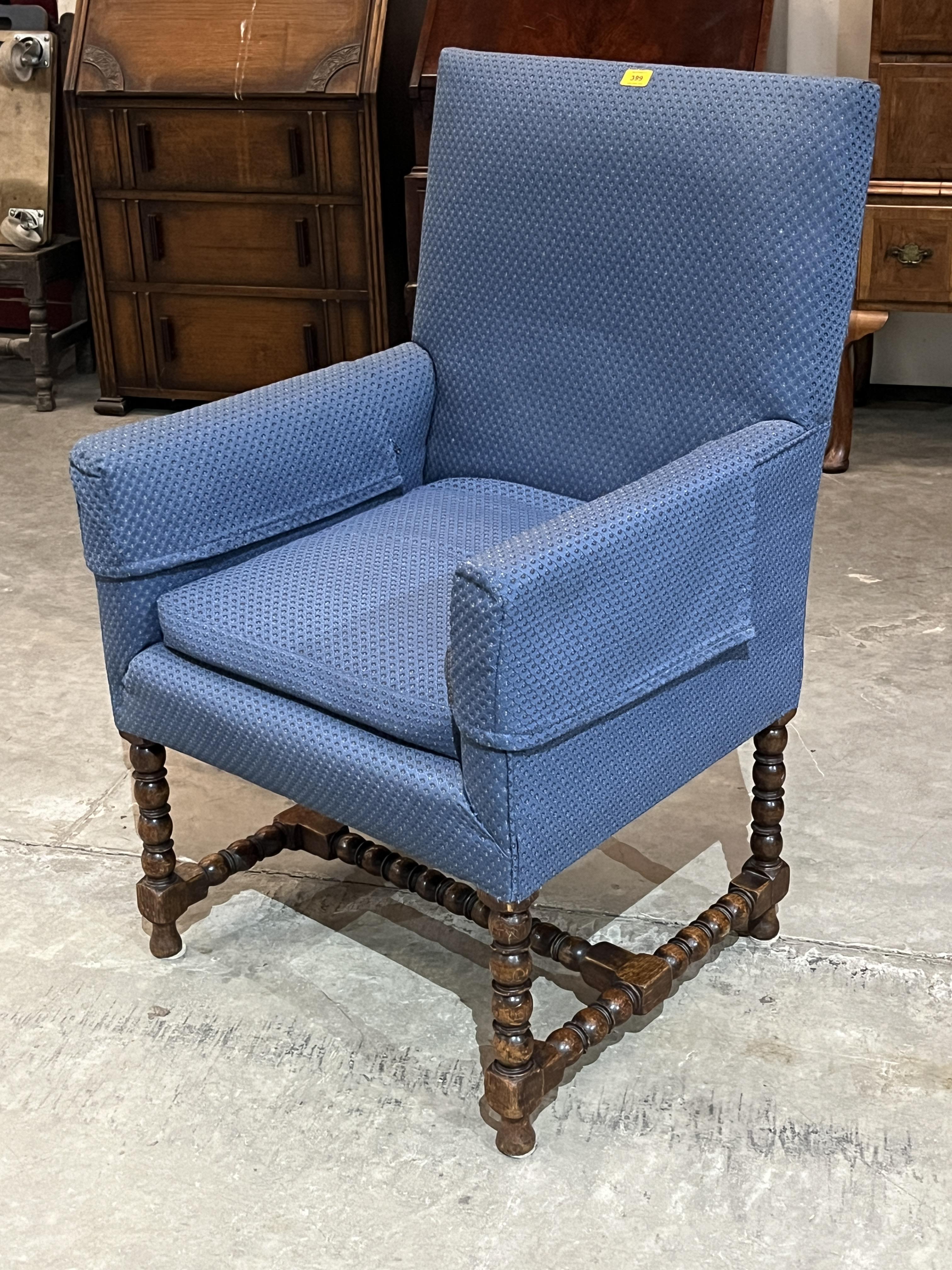 An upholstered armchair on oak bobbin turned supports and stretchers.