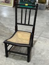 A Victorian bobbin turned bedroom chair with caned seat.