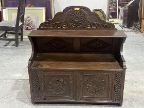 An oak mural cabinet enclosed by a pair of carved panel doors under a display shelf. 33" wide, c.