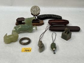 A collection of Chinese carved jade objects and wood stands. The horse AF.