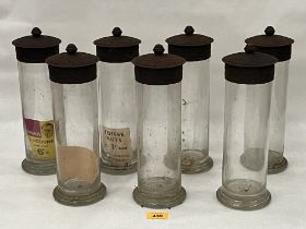 Seven Rowntree Gums glass jars with embossed metal covers. 11½" high, c. 1900-1920.