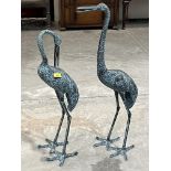 A pair of decorated bronzed metal crane garden ornaments, 33" high and smaller.