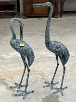 A pair of decorated bronzed metal crane garden ornaments, 33" high and smaller.