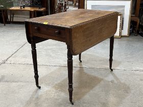 A 19th Century mahogany Pembroke table with drawer and blind drawer, on ring turned tapered legs.