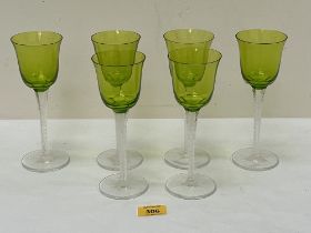 A set of six Lalique wine glasses, the green bowls on facetted scroll engraved stems. 7¼" high.