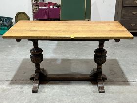 An oak refectory style dining table on carved cup and cover end support. 54" long