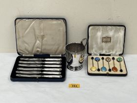 A cased set of six cake knives with loaded silver handles; a set of six enamel plated coffee