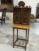 A Victorian walnut mural cupboard enclosed by a pair of blind fret carved doors, 24" high,