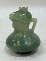 A Chinese green jade jug and cover, carved in the form of a cockerel. 3" high.