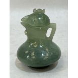 A Chinese green jade jug and cover, carved in the form of a cockerel. 3" high.