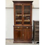 A Victorian walnut bookcase enclosed by a pair of glazed doors over a pair of drawers and conforming