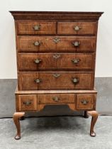 A George II walnut chest on stand with two short over three long herringbone banded graduated