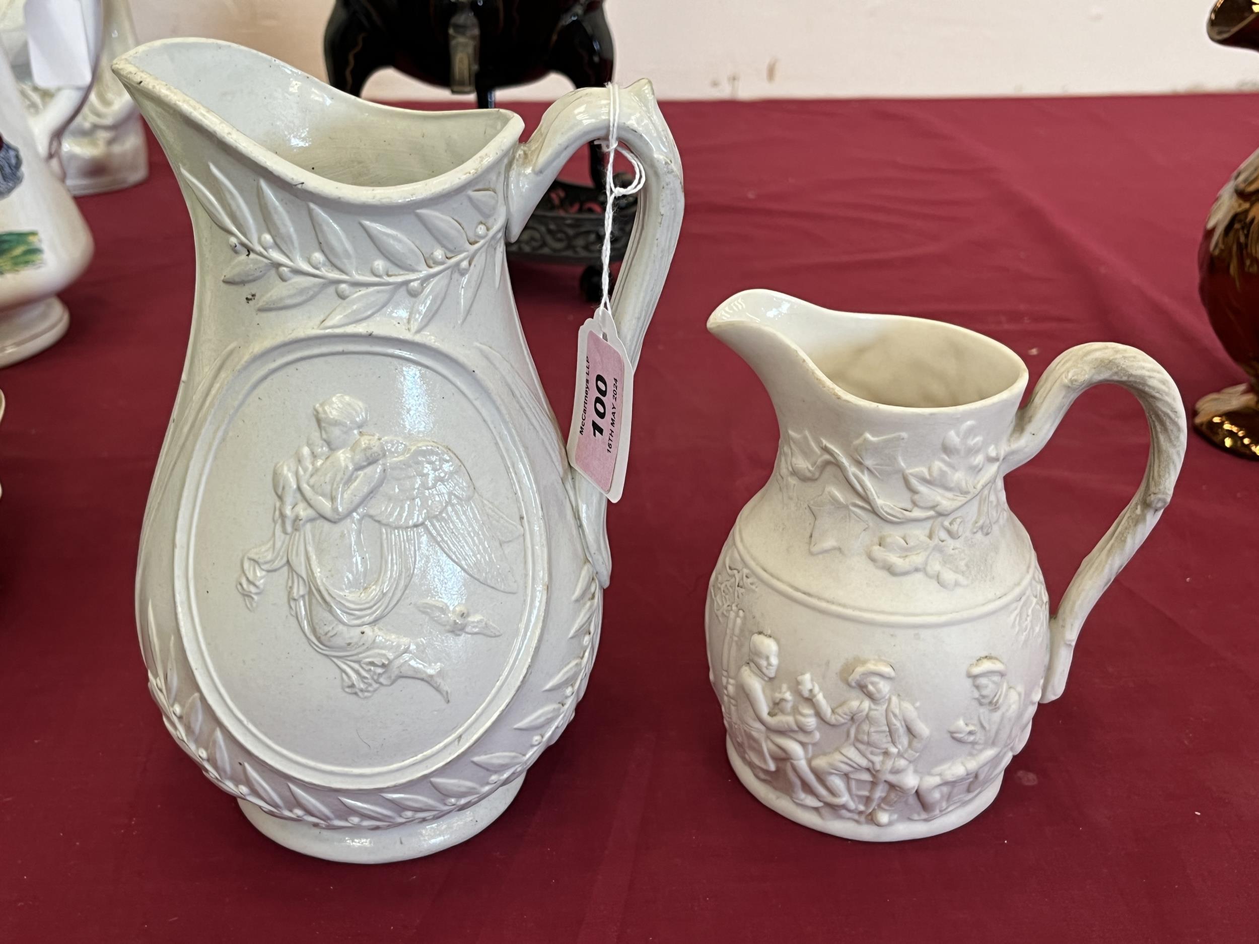 Two Victorian relief decorated parian jugs, the larger 8" high.