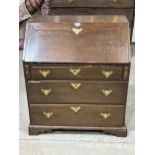 An 18th Century oak bureau with fitted interior over three drawers on bracket feet. 30½" wide.