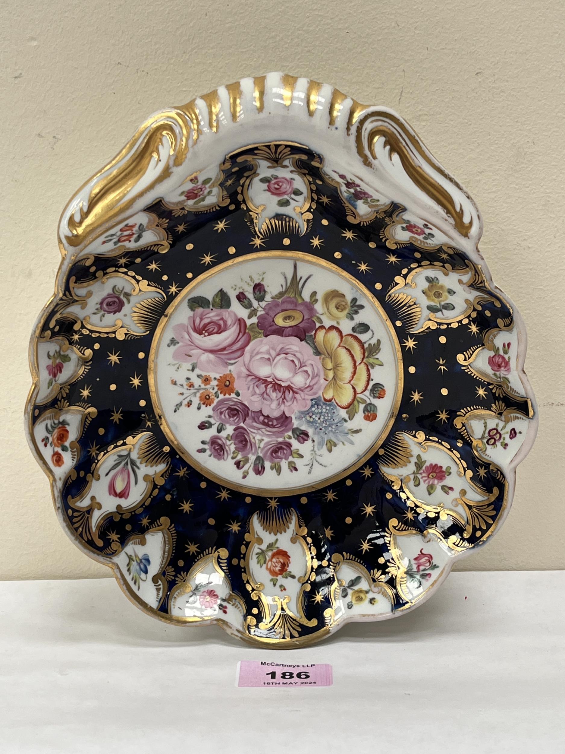 A 19th Century scalloped dish, gilded and painted with reserved summer flowers on a mazarine ground.