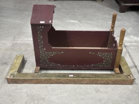 A painted cradle and a brass fire curb.