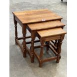 A nest of three oak occasional tables.