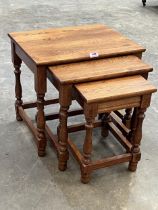 A nest of three oak occasional tables.