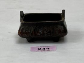 A Chinese bronze censer of rectilinear form with moulded decoration and single character mark to