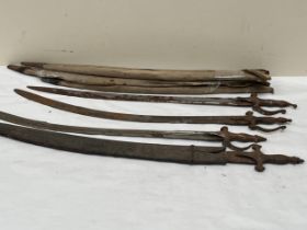 Three Indian sword Tulwars with wood and canvas scabbards and another with leather scabbard.