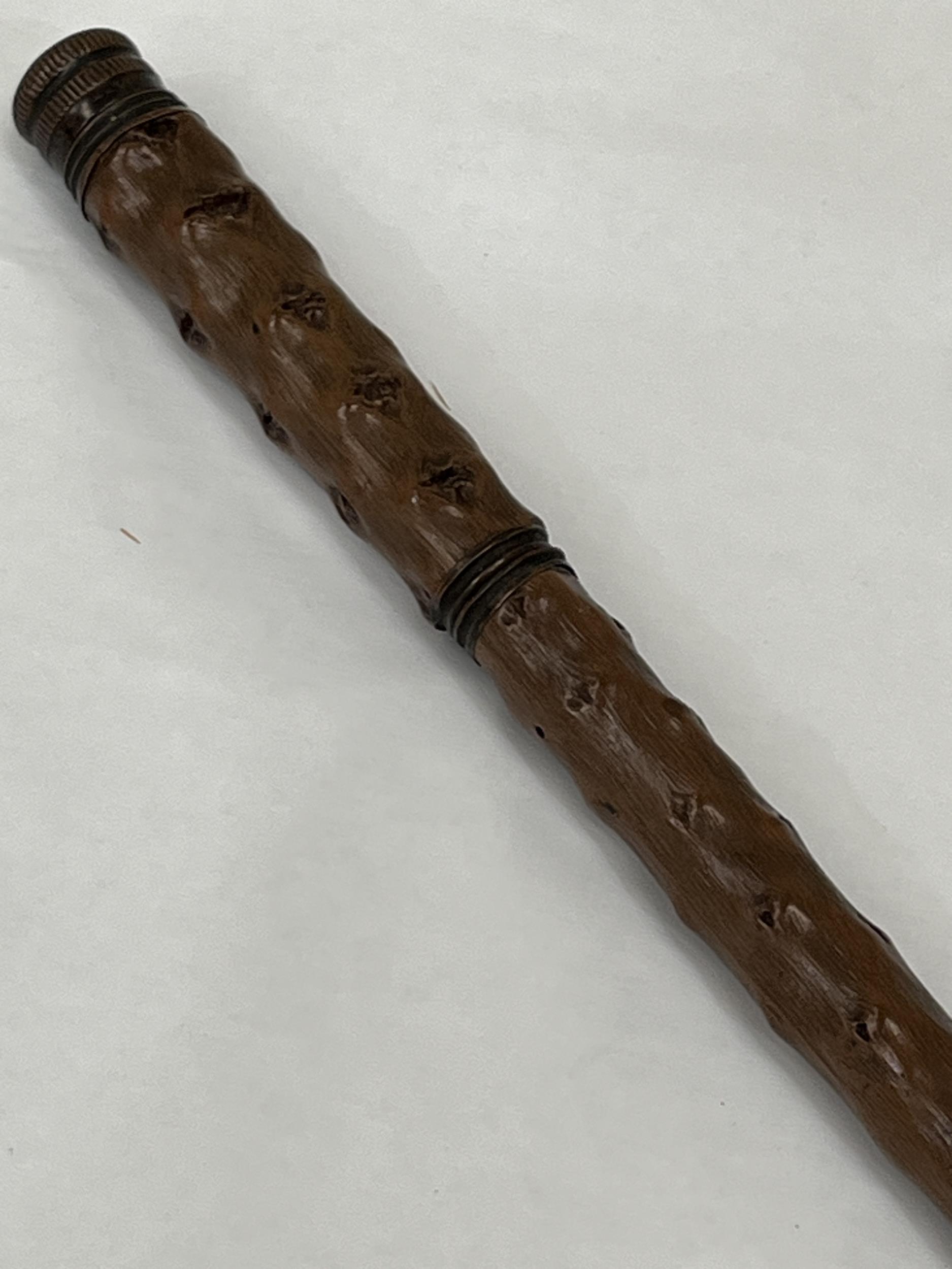 A 19th Century walking cane with screw compartments for a glass bottle and drinking glass. 36"