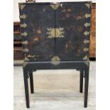 A George II black lacquer and gilt chinoiserie decorated cabinet on stand, the pair of fretted and