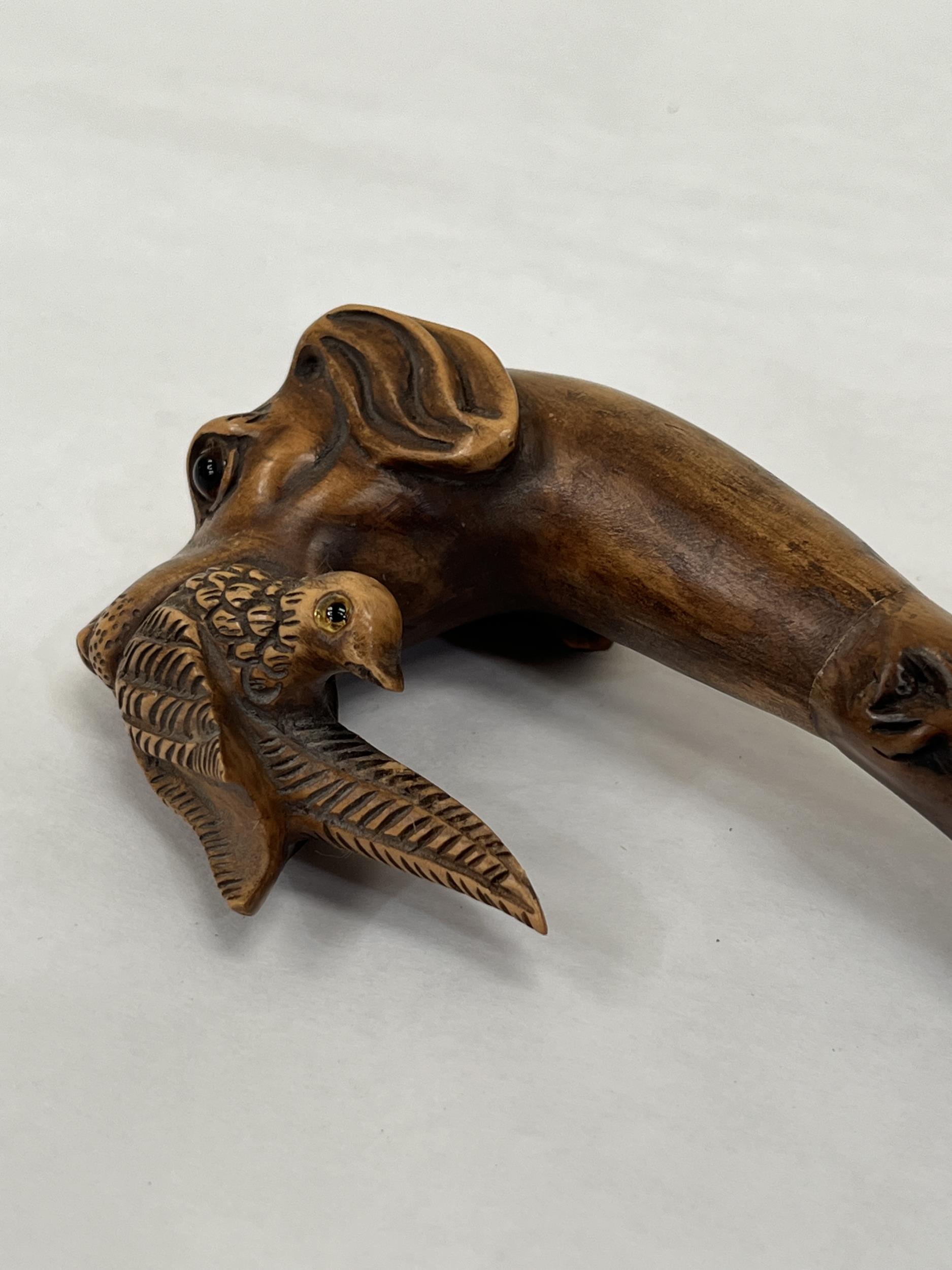 An Edward VII blackthorn walking cane, the pommel carved as a glass eyed hound's head with gamebird, - Image 2 of 3