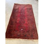 A red ground Eastern rug. 85" x 45".