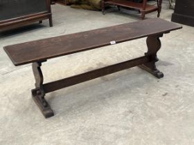 An oak bench on shaped trestle supports. 54" long.