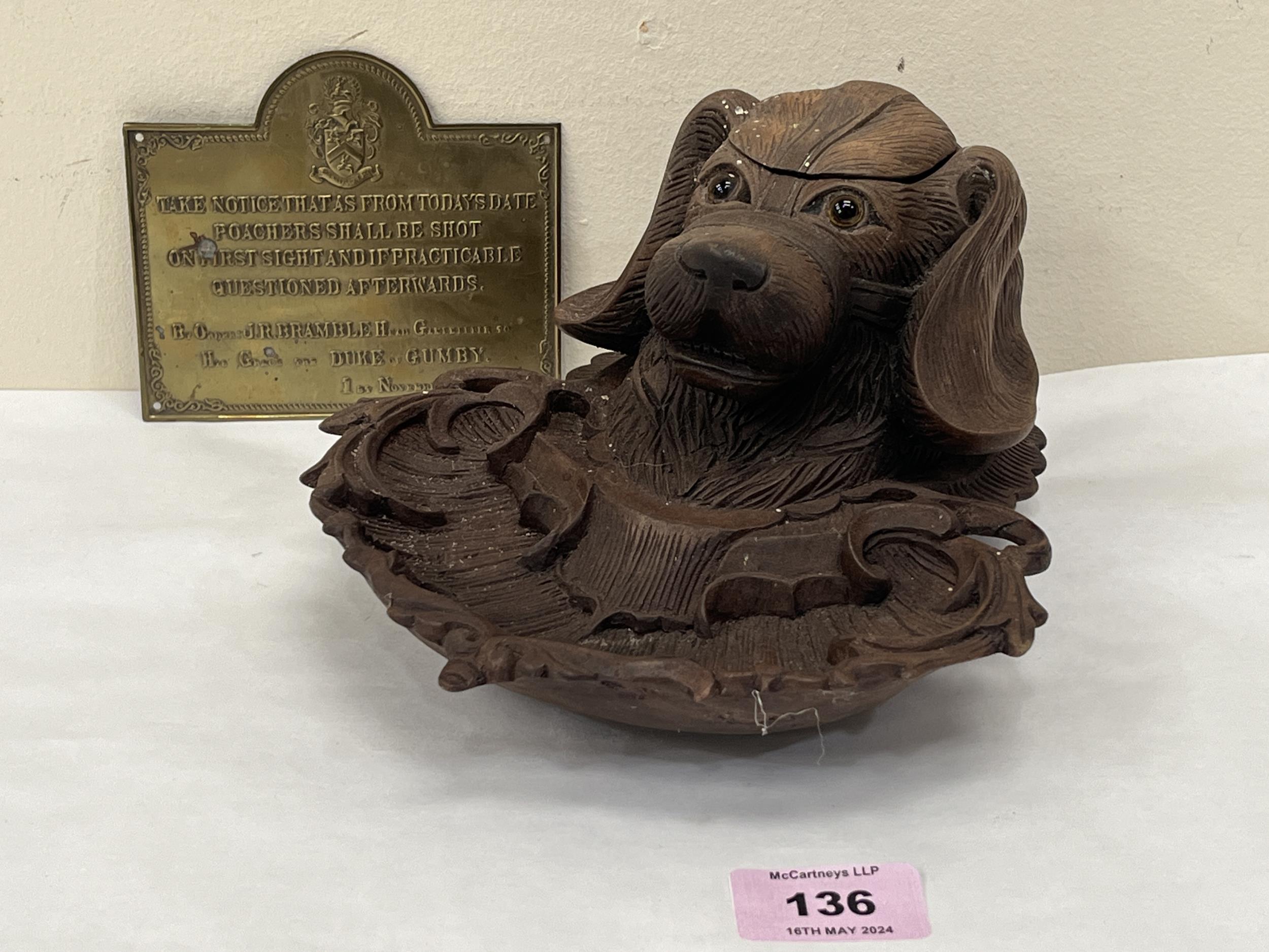 A Black Forest type inkstand, carved as a dog's head with glass eyes, 8½" long; together with a