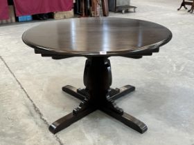 An Ercol dining table with concealed leaf. 45" diam.